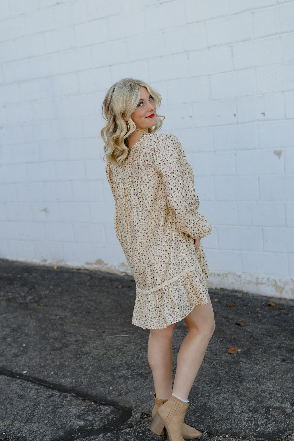 Beige babydoll dress with dark red floral pattern; long in the back and short in the front with velvet bow along neckline