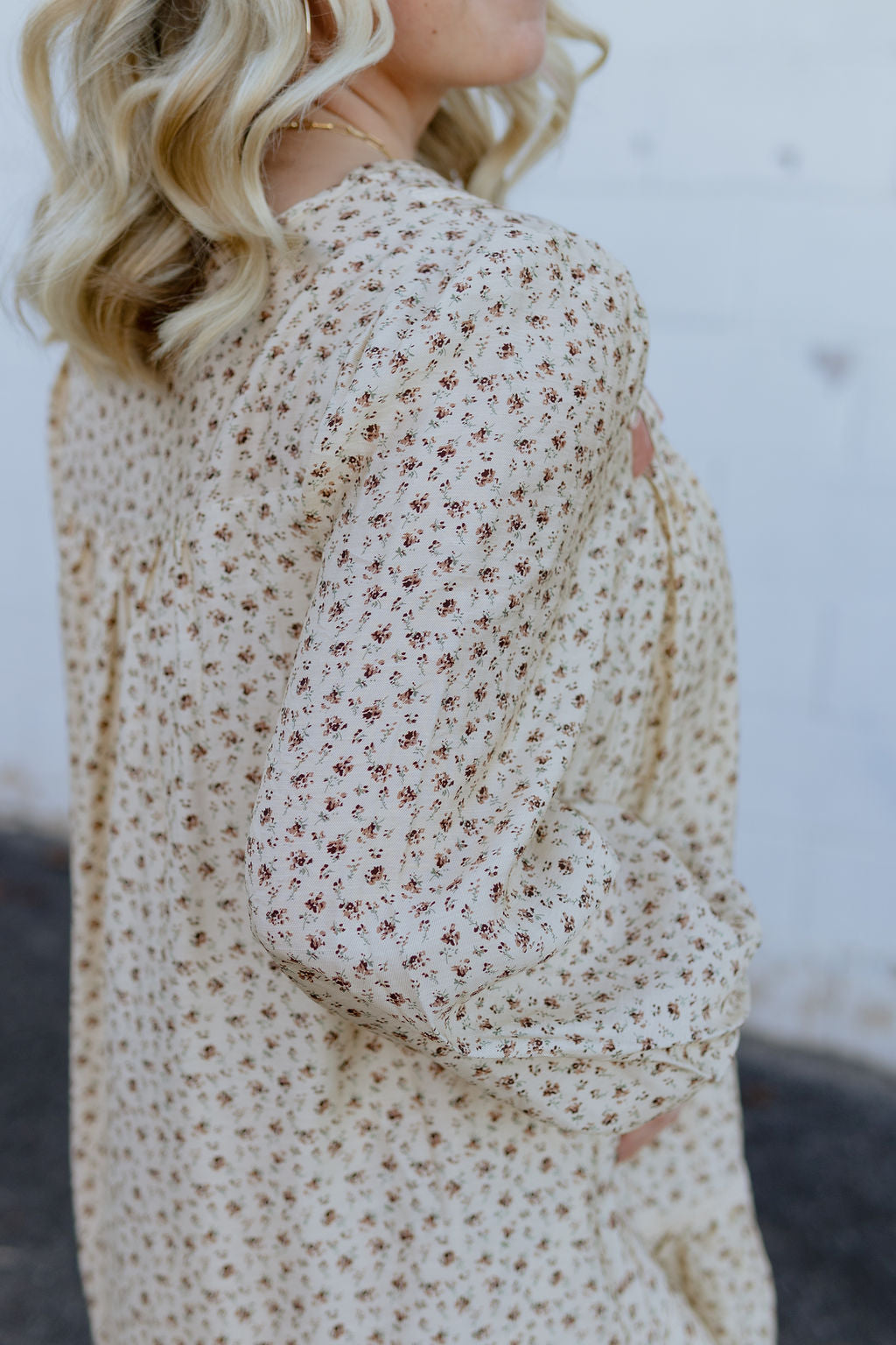 Beige babydoll dress with dark red floral pattern; long in the back and short in the front with velvet bow along neckline
